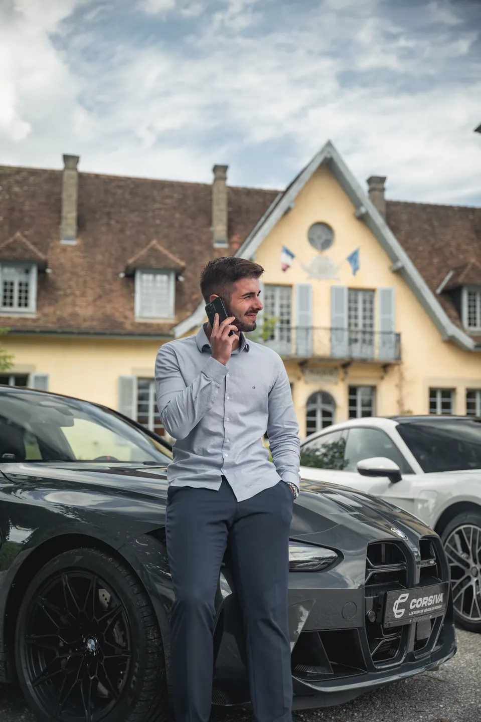Un conseiller Corsiva au téléphone devant une BMW M3