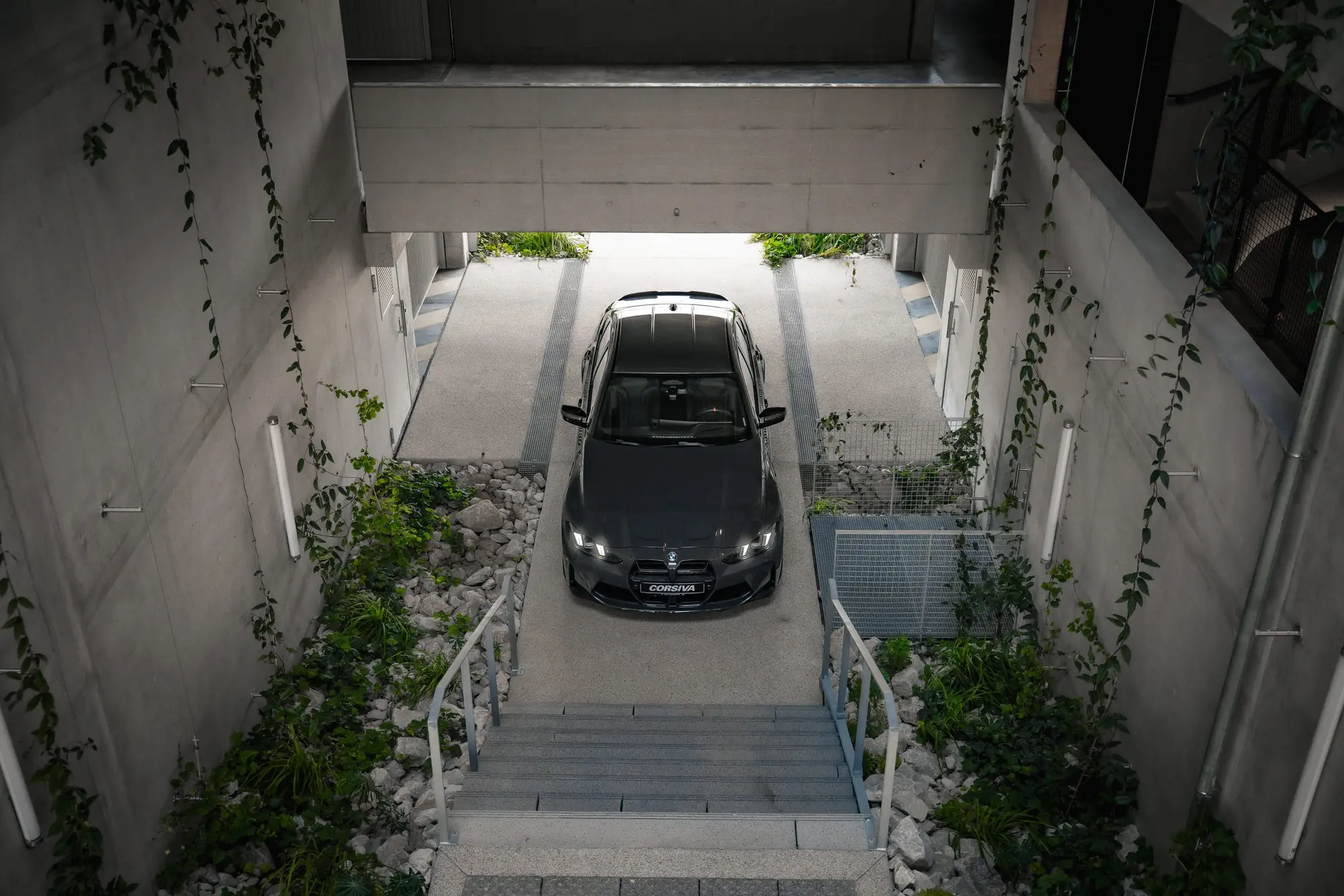 BMW M3 Competition du groupe Corsiva dans la descente du garage, vue d’en haut