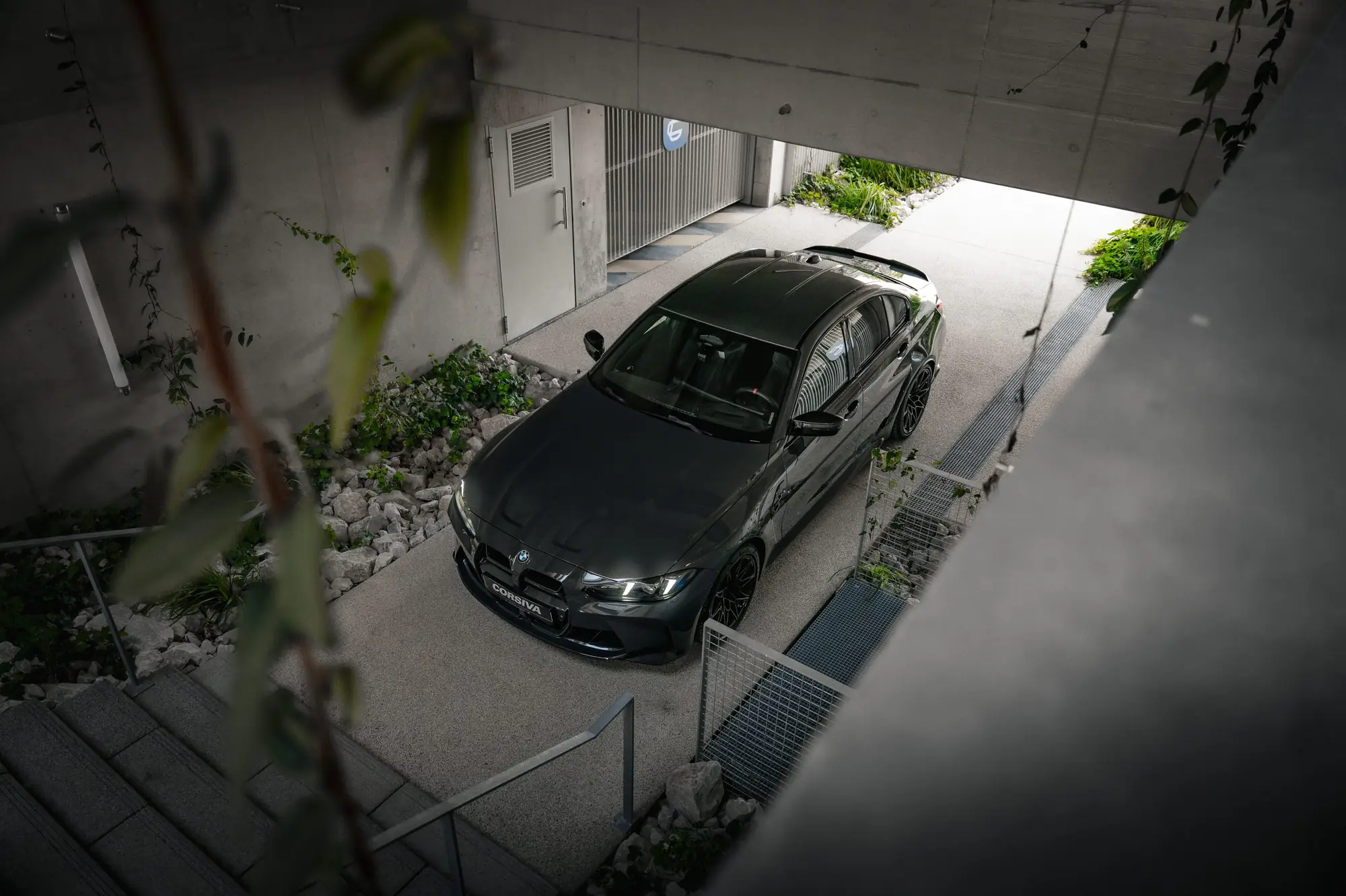BMW M3 Competition du groupe Corsiva vue d’en haut, dans la rampe du garage